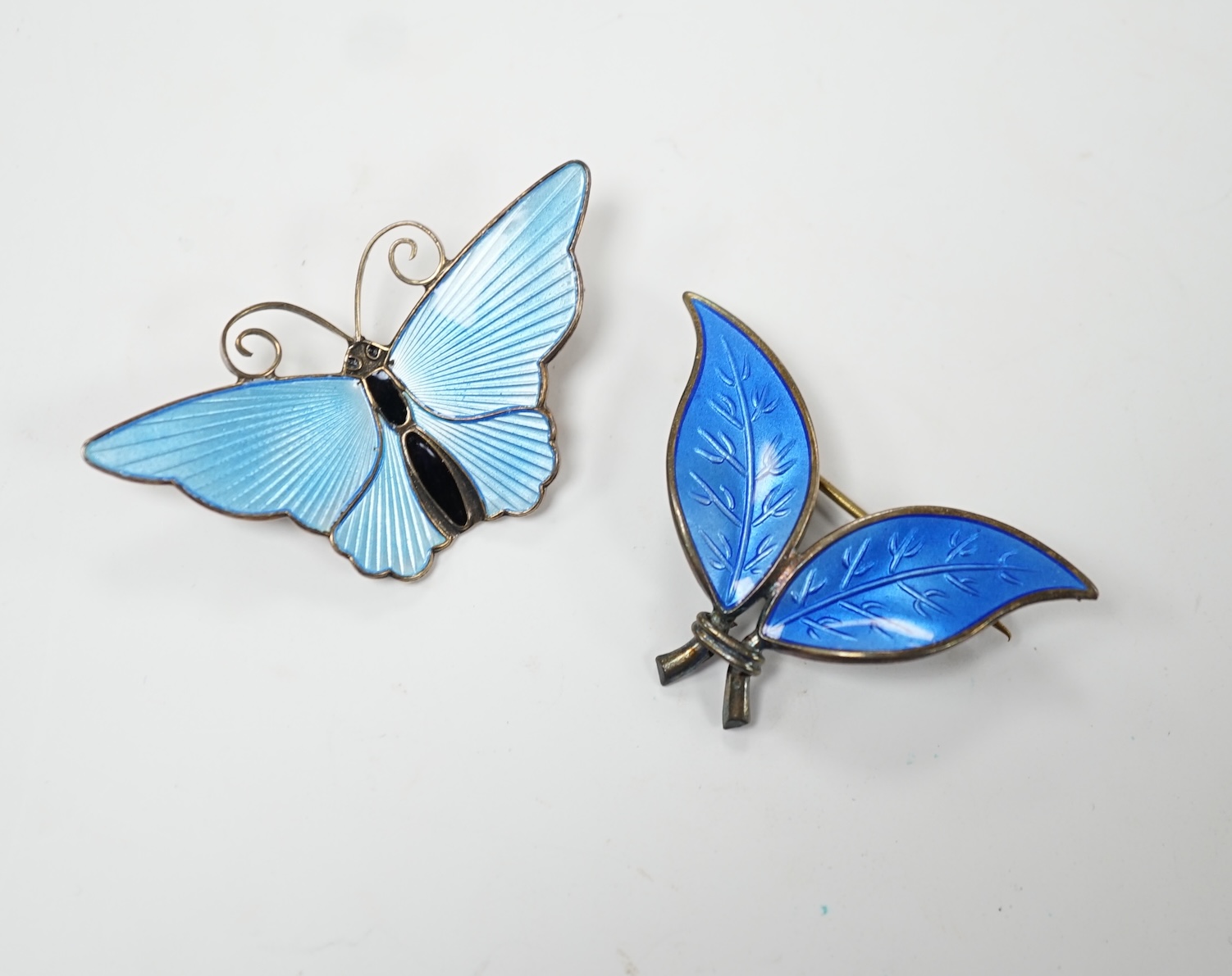 A 20th century Norwegian sterling and blue enamel set butterfly brooch by David Andersen, width 43mm and a similar double leaf brooch by David Andersen. Good condition.